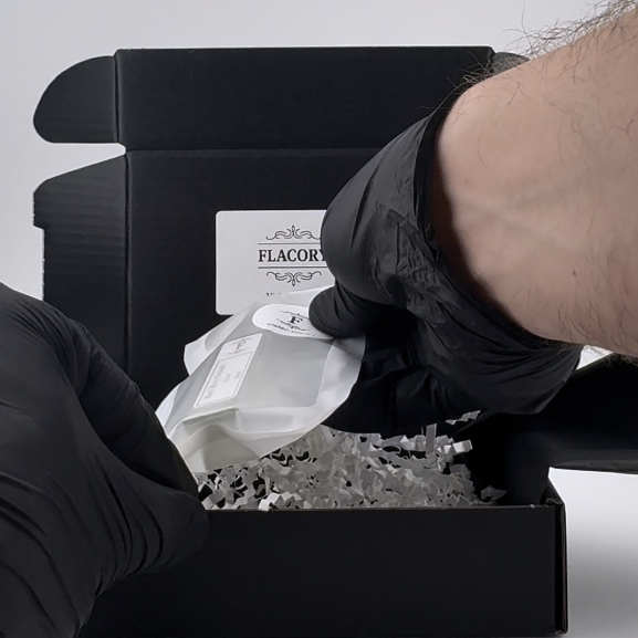 Parfumproben werden in eine schwarze Flacory Versandbox gelegt