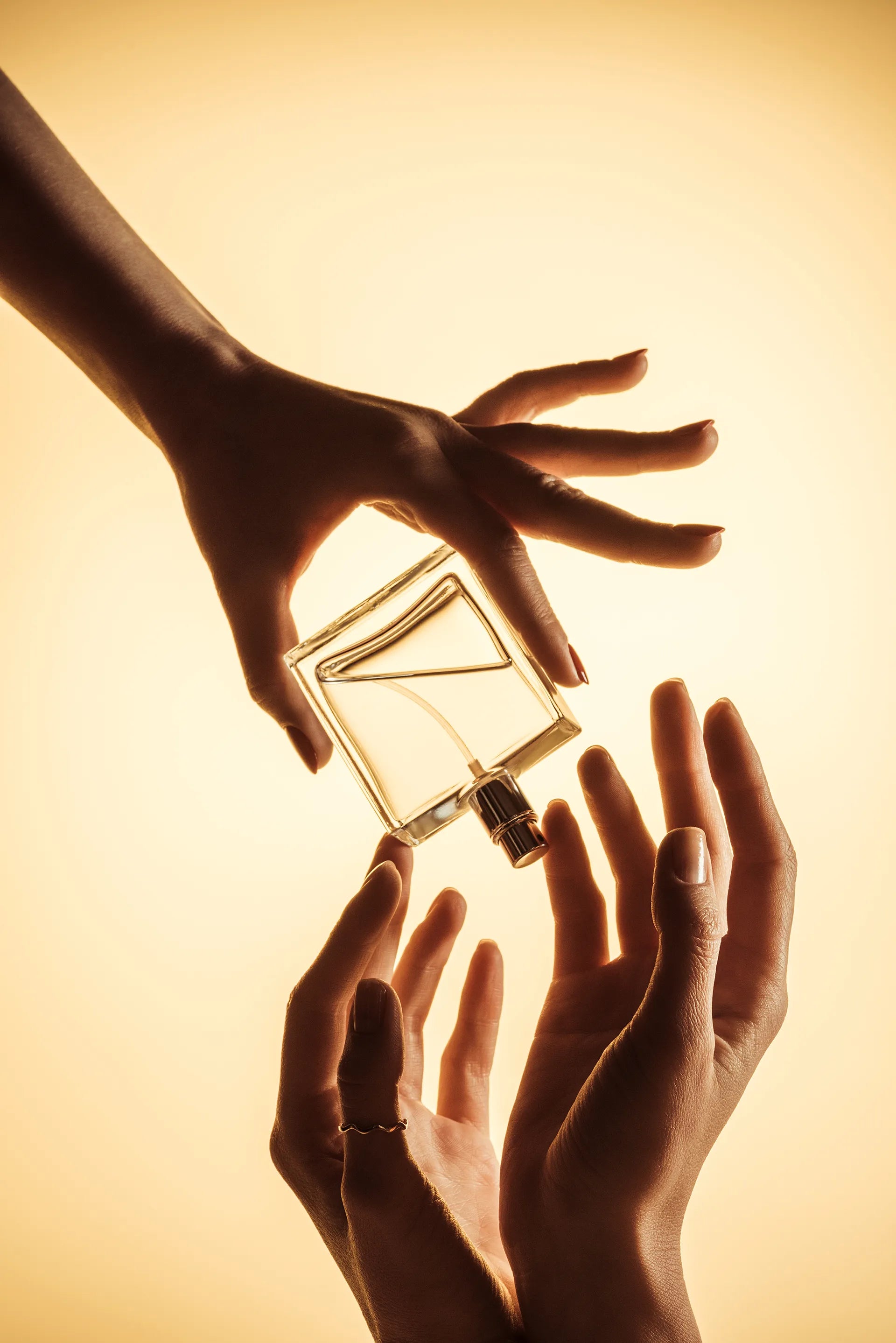 Frau hält Parfumflakon in der Hand